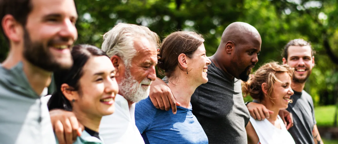 Diverse group of people outdoors smiling and embracing
